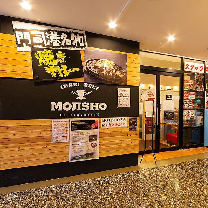 門司港名物焼きカレーを写真付きで大きく紹介している黒と木目が基調の「レストランMOJISHO」の外観
