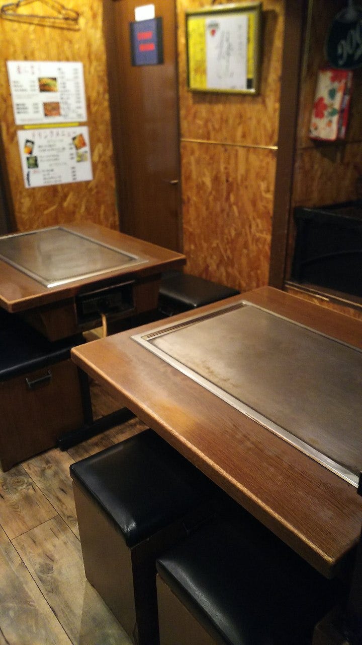 鉄板付きのテーブル席に黒いイスが並んでいるきじ本店内