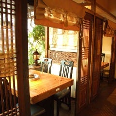 韓国格子・暖簾で仕切られたプライベート空間。木の暖かみと窓から望むテラス席・緑で心行くまで寛げる。