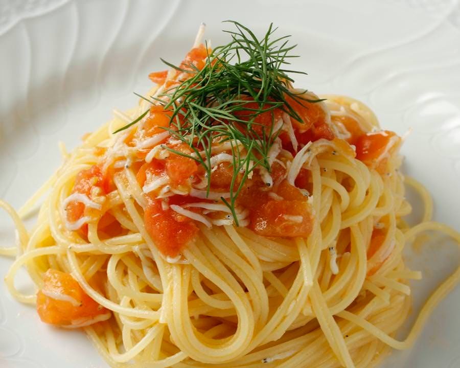 白い皿に盛られたシラスとフレッシュトマトのスパゲッティ