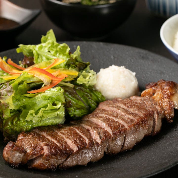 黒色の丸いお皿にのったステーキ