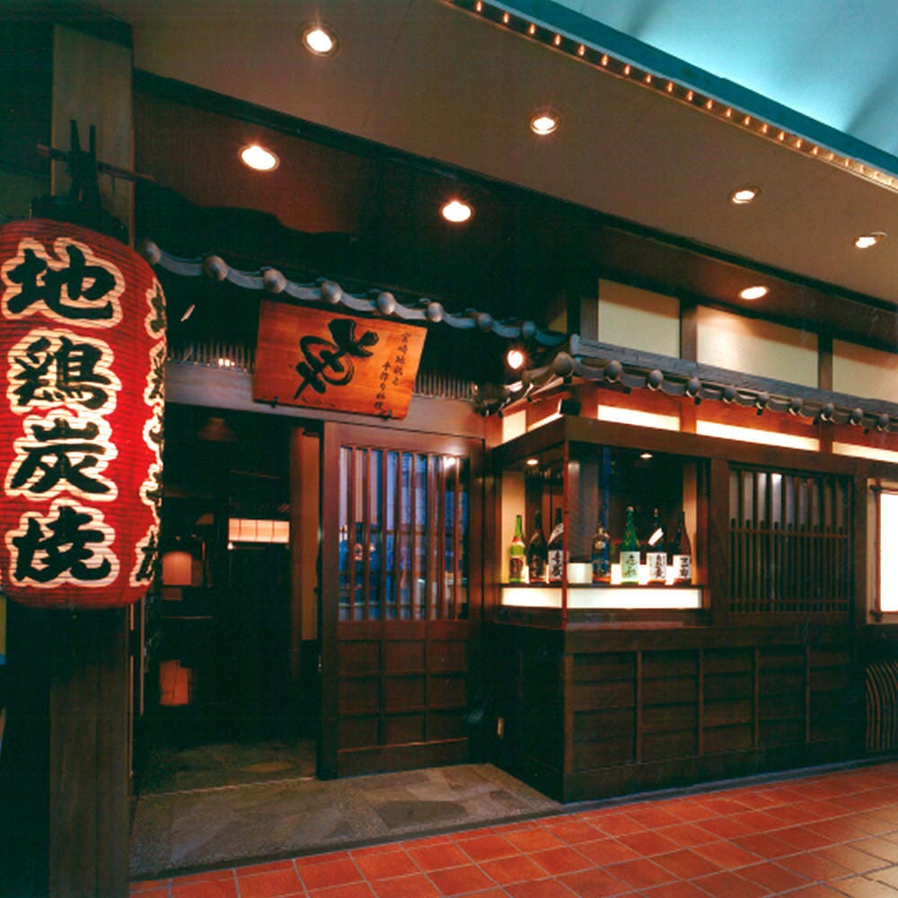 大きな赤提灯と木彫り看板、格子戸がある車江坂店の外観
