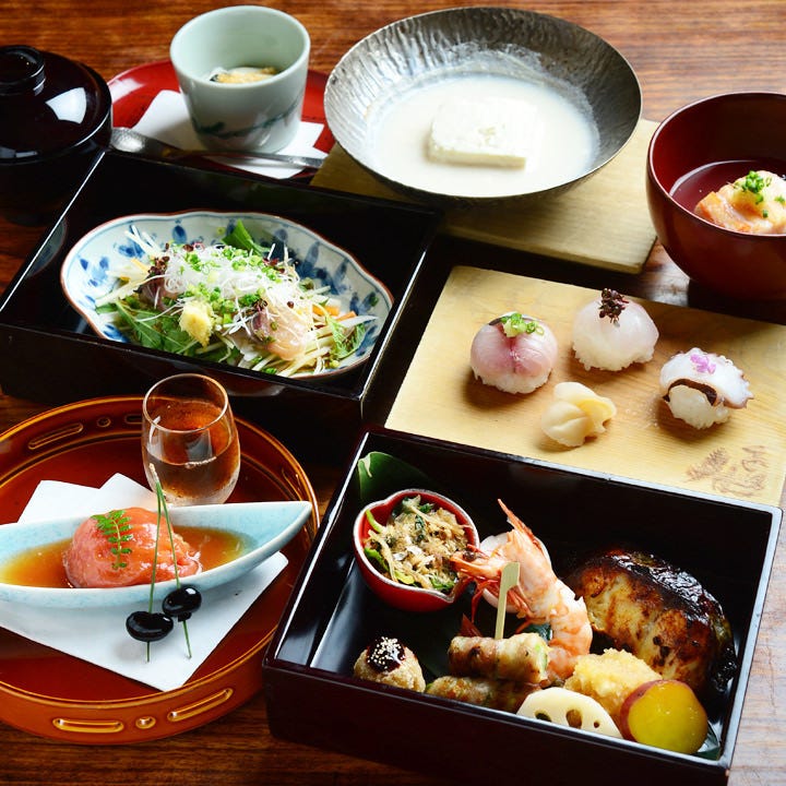 懐石料理風の手まり寿司や、小鉢に入った料理が並んだランチコース