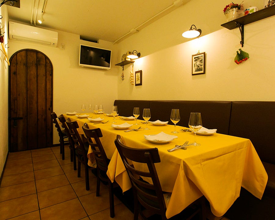 トラットリア ラ タルタルギーナの黄色いテーブルクロス席