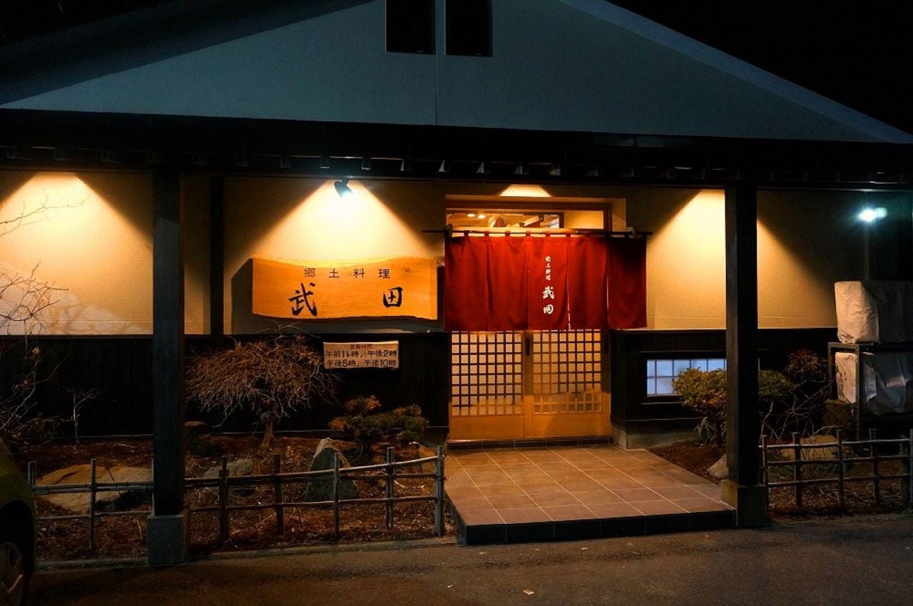 入り口がライトで照らされている郷土料理武田の外観