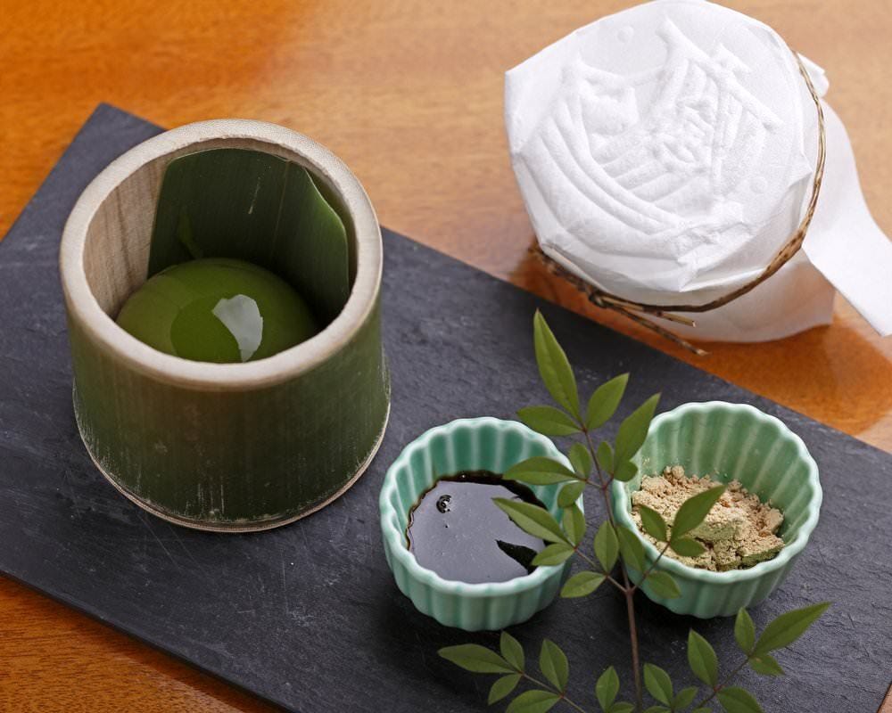 竹の器に入った抹茶の翡翠もちと黒蜜ときな粉