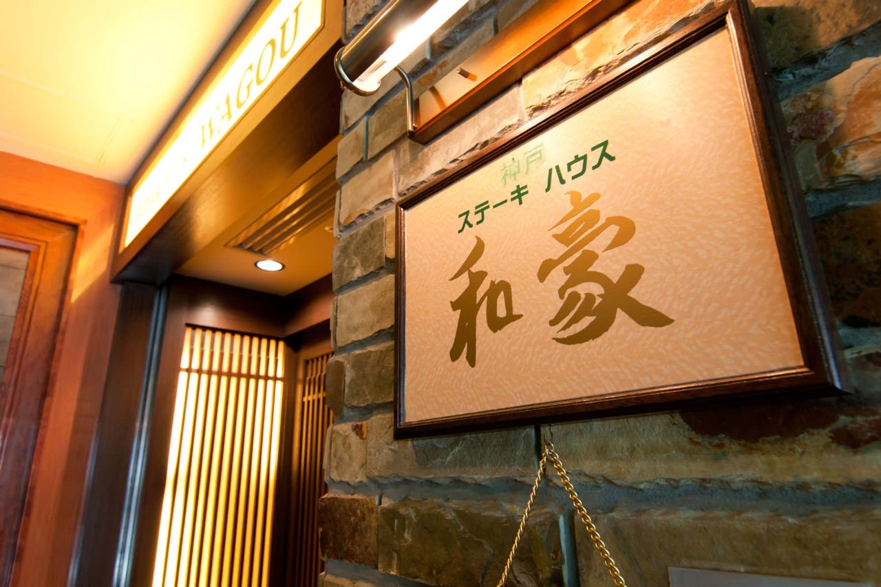 白色の看板に店名ロゴが入った「神戸ステーキハウス 和豪」の店前