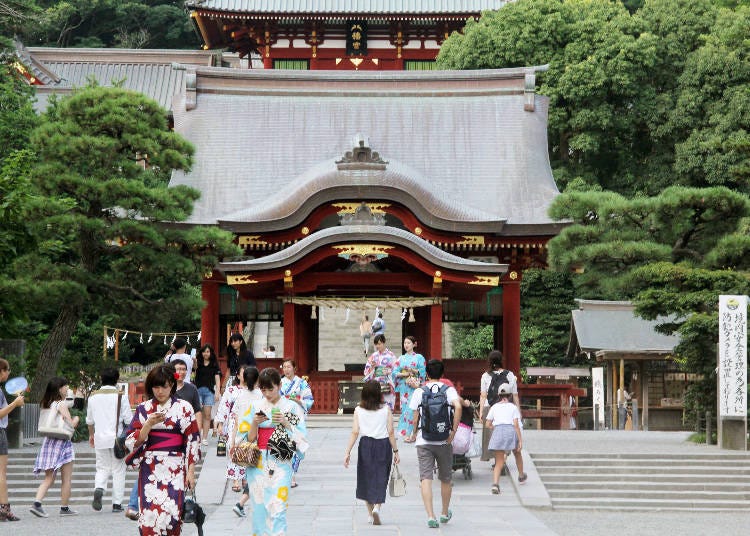 The shrine’s stage called “maiden” and the main building in the background, seen from the shrine approach.