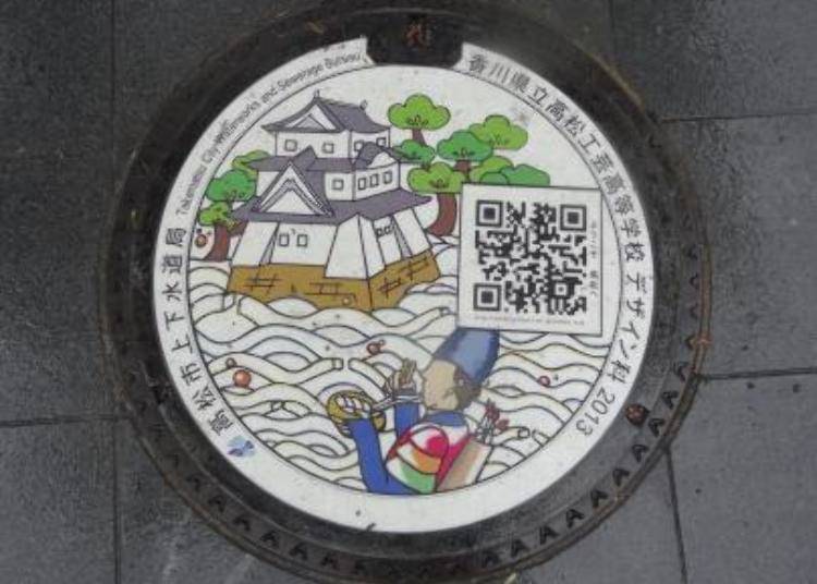 The manhole design of Takamatsu City, depicting Takamatsu Castle, its magnificent pine trees, and Nasu no Yoichi, a famous samurai commander. He eats udon, the local specialty. Scanning the QR code will display information about sightseeing spots and restaurants around the area.