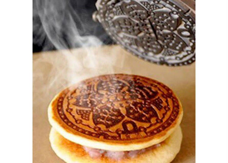 Above is a photo of the summit filled with cheers for manhole covers. The manhole dorayaki, a sponge cake with red bean jam, popular among the participants, features a manhole cover design commonly seen in Tokyo.