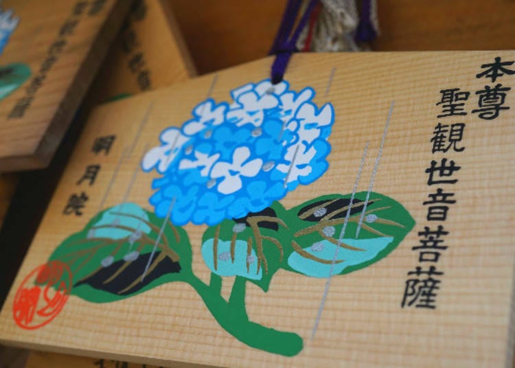 ▲ A wooden wishing plaque called “ema,” decorated with an illustration of hydrangea.