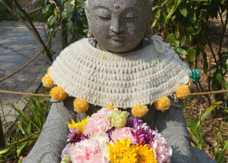 ▲ A “flower jizo,” Buddhist guardian of children, holding seasonal flowers. In June, he’ll have hydrangeas in his hands.