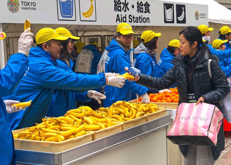 Volunteers handing out bananas and mandarin oranges