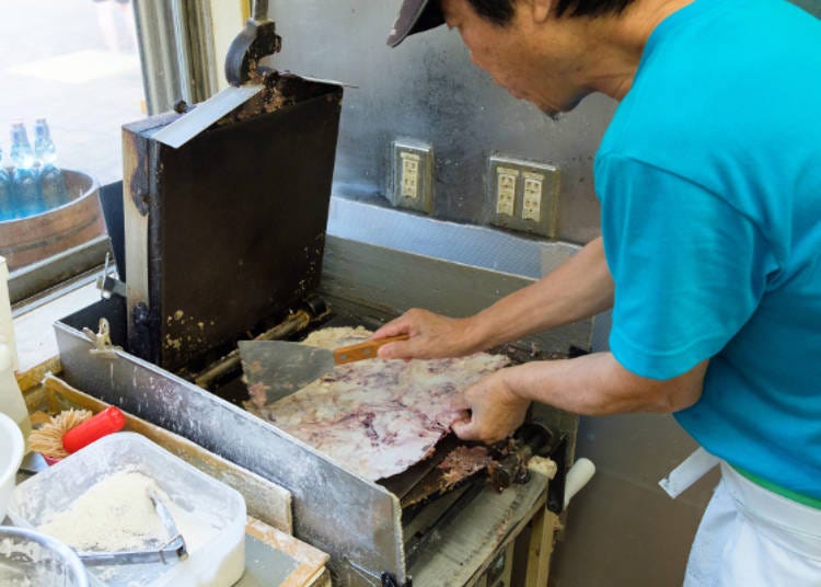 After the first pressing, the chef adjusts the shape and presses the cracker once more.