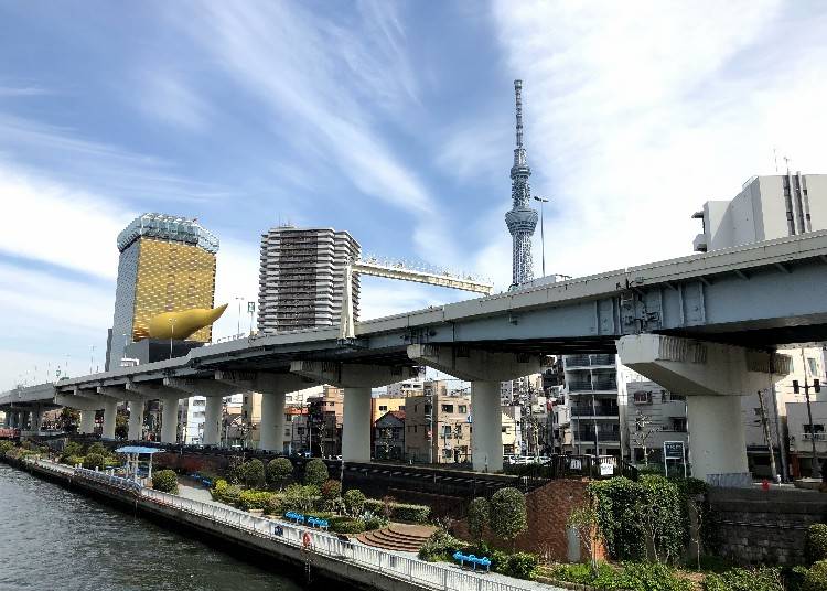 Caption: You can see Tokyo Sky Tree when you walk along Komagata Bridge. The gold-colored object you see in the distance is the symbol on the Asahi Beer Building symbolizing the “Flame of the Sacred Stand”.
