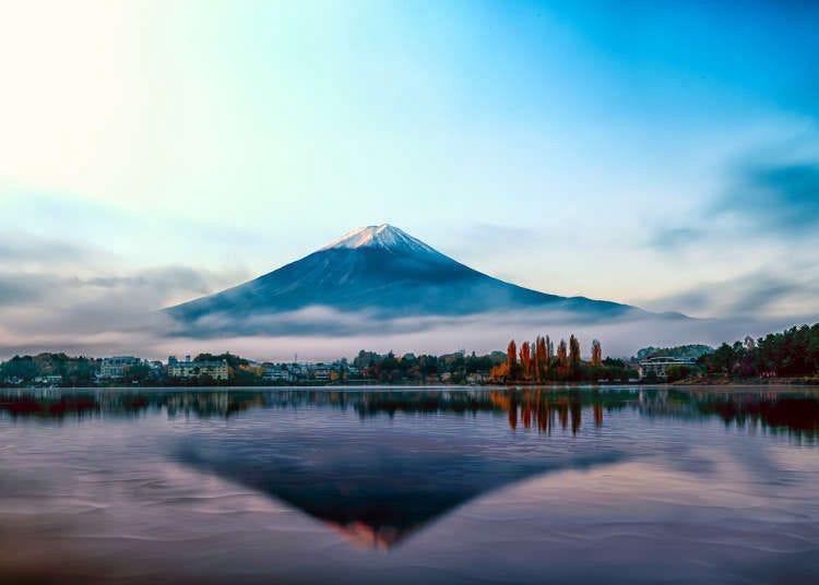 Premium Photo  A pink moon over a lake with mountains in the background