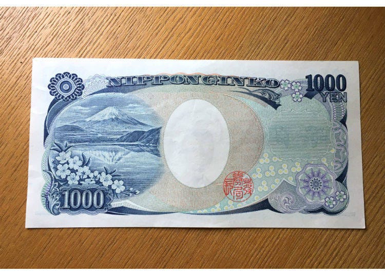 The backside of the 1,000-yen bill shows Mount Fuji Upside-down together with cherry blossoms.