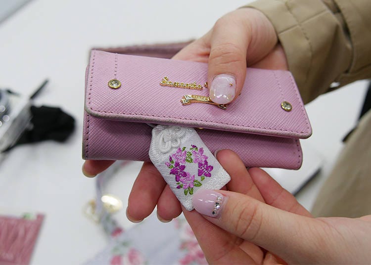 A charm called “omamori,” adorned with pink flowers.