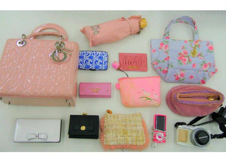 Top center: parasol-umbrella / top row (from the left): her main bag, a card case, a commuter pass case, a tote bag / center row (from the left): key case, accessory bag 1, makeup pouch / bottom row (from the left): phone charger, wallet, accessory bag 1, iPod, camera