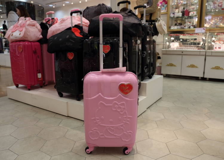 A red heart sits on the pink suitcase.