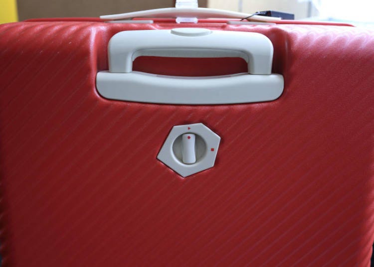 The 75L suitcase. The switch underneath the handle lets you lock the wheels in place.