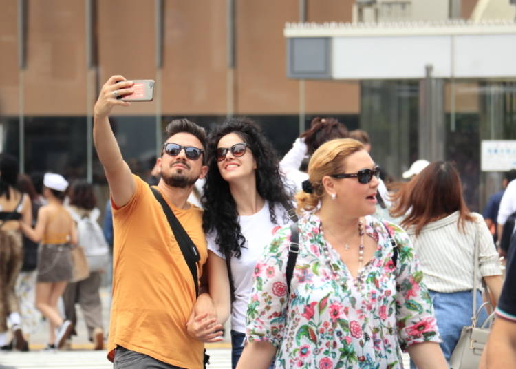 Many tourists enjoy taking selfies at the center of The Scramble