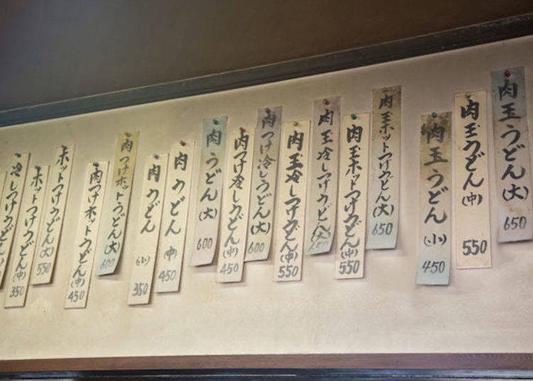 The menu at Watanabe Udon has remained unchanged since the shop first opened. Dishes like Niku Udon and Niku Tsuke Hiyashi Udon have kept their original prices, offering great value without any increases over the years.