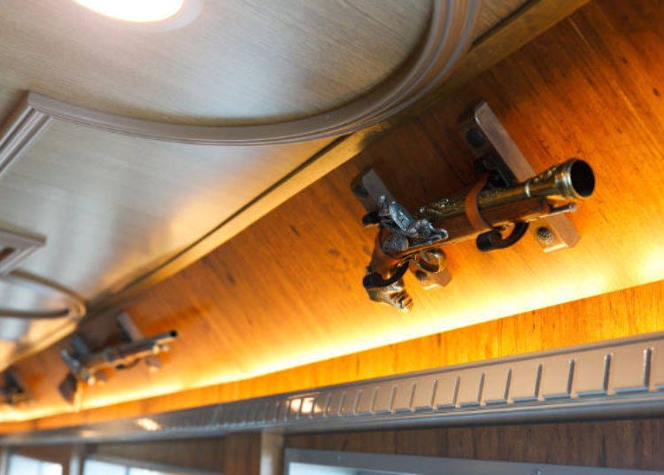 ▲ Above the window there are several replicas of hand guns and rifles that gives the image of an old warship.