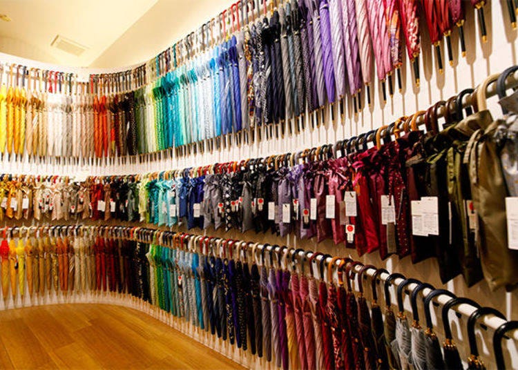 So many colors! About 400 umbrellas adorn the wall. The top row shows long umbrellas, the middle row is folding umbrellas, and the bottom row is short umbrellas.