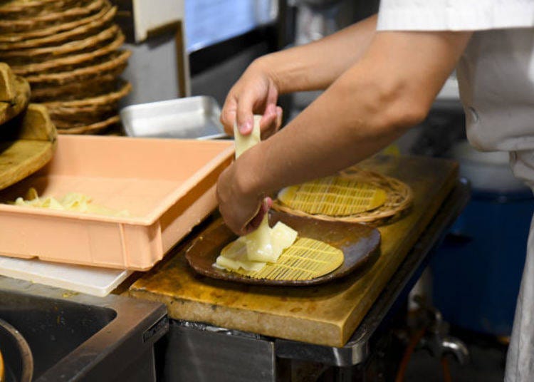 The cooked noodles are rinsed under running water and arranged neatly.