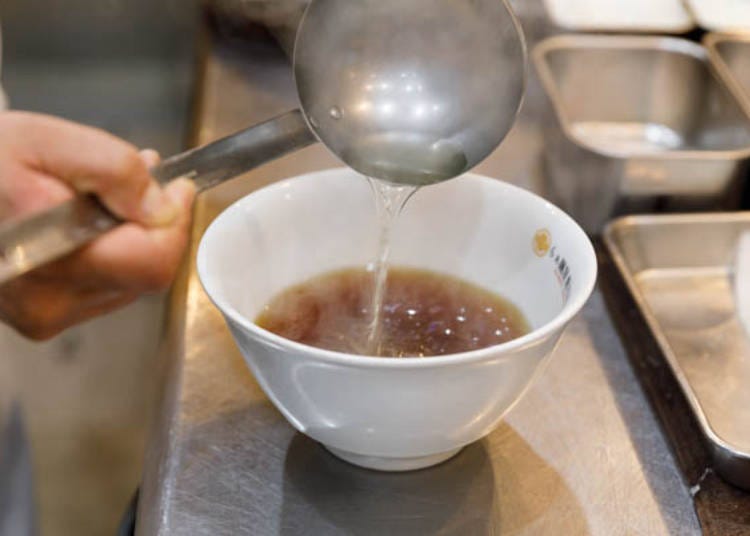 ▲ Pouring the broth into a bowl with the chicken oil and soy sauce