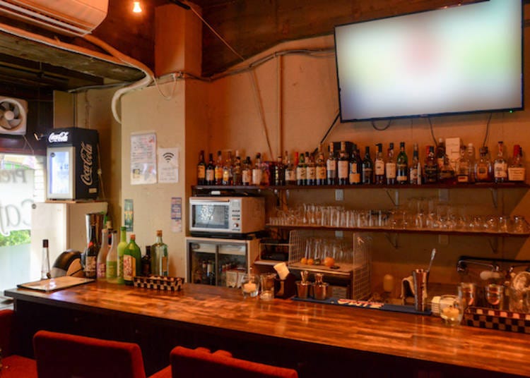The bar features a large-screen monitor and counter seats
