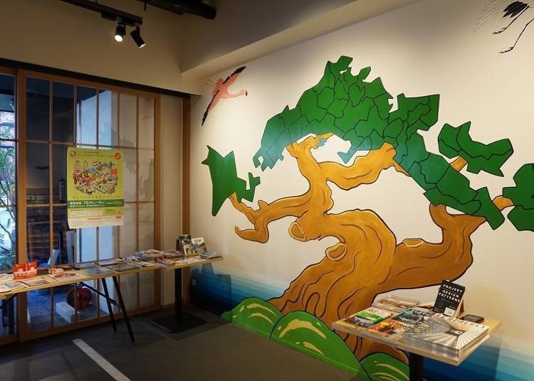 Wall art depicting the map of Japan as a pine tree as well as a hanging scroll that illustrates the current season
