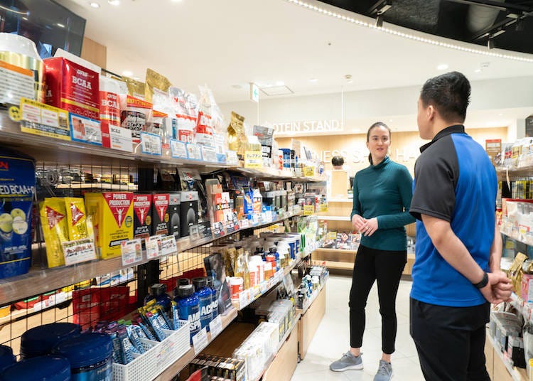 A customer consults with English-speaking staff about supplements in Japan.