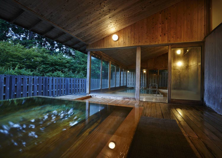 Semi-open-air Onsen F lined with dark greenery