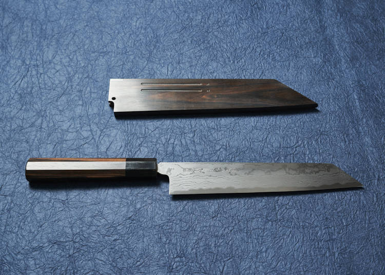 Kiritsuke santoku in Damascus finish with rosewood handle and sheath—240 mm in length (¥31,900, including tax).