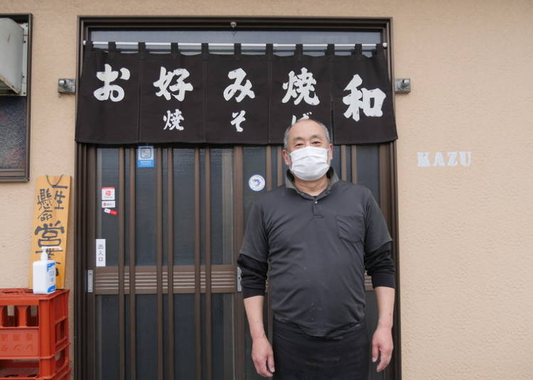 The shop owner cheerfully welcomes us.