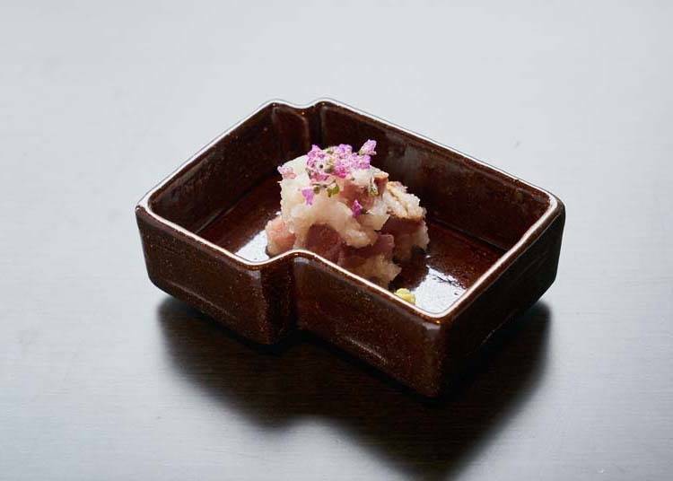 Amberjack sashimi flavored with fine daikon radish and garnished with alpine flowers.