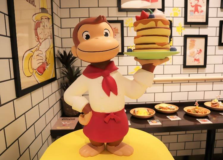 George dressed as a cook with a stack of pancakes.