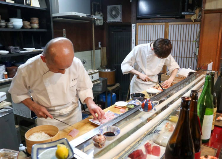 Sushi being masterfully prepared one by one in front of our eyes