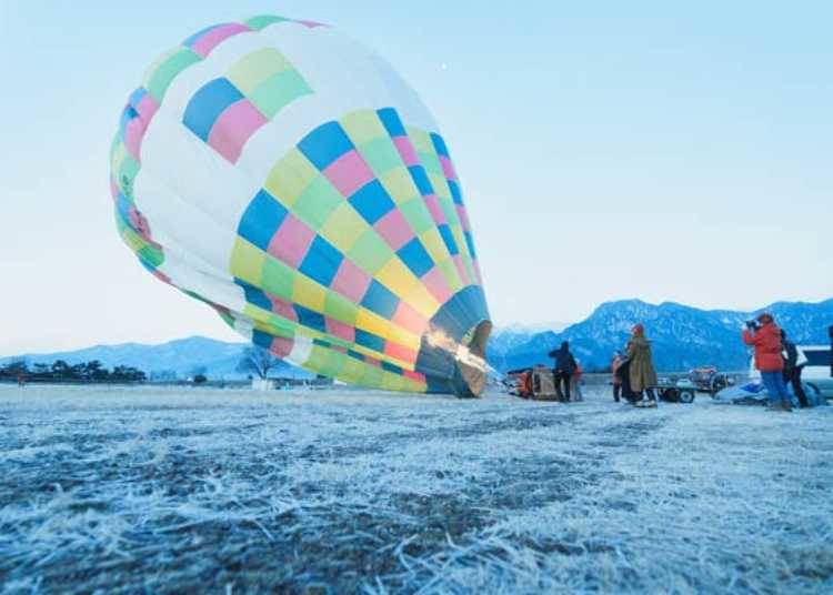 ▲熱気球は冬の冷たい外気とバーナーで暖めた空気の温度差を利用して大空へと飛び立つ