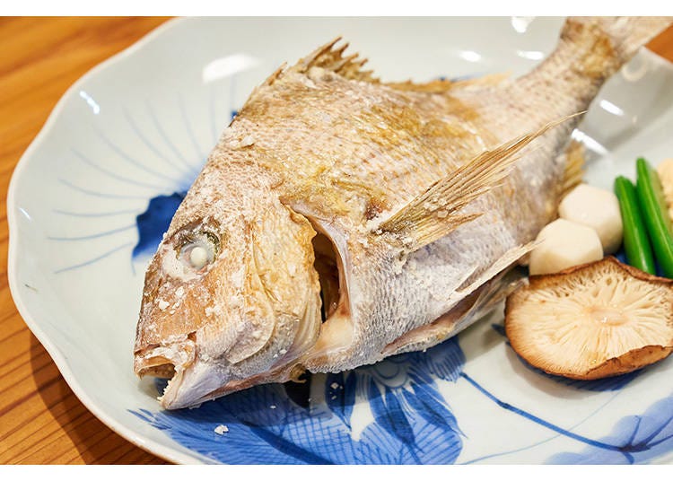An entire sea bream is grilled over a charcoal fire for 30 minutes and sprinkled with salt. The meat of the fish is plump and tender.