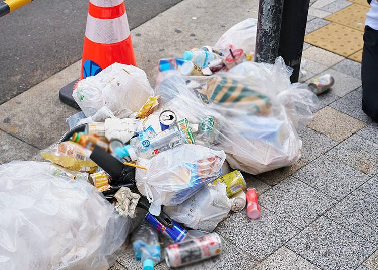 Trash left on corners of the streets by nearby businesses and passersby.