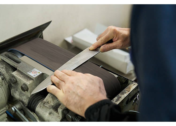 Seiichi Kamata at the storefront whetstone-sharpening station.