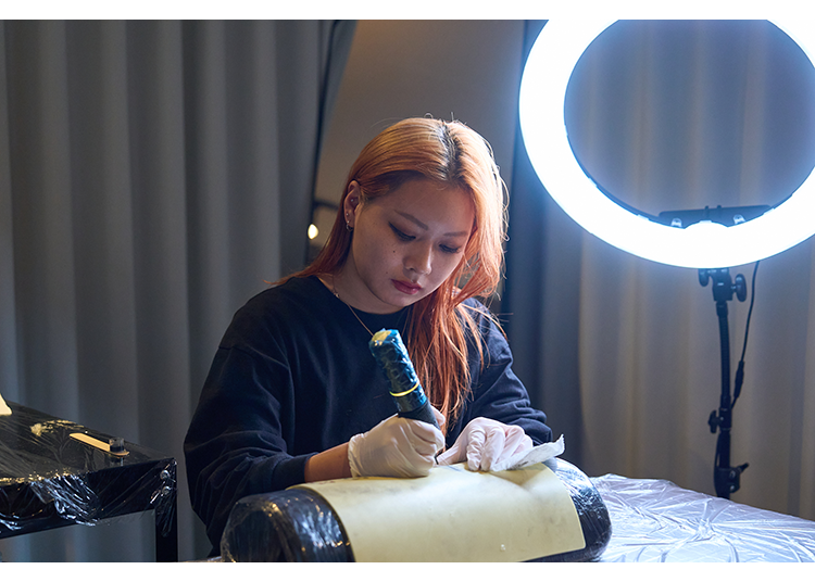 A young artist practices on fake skin.