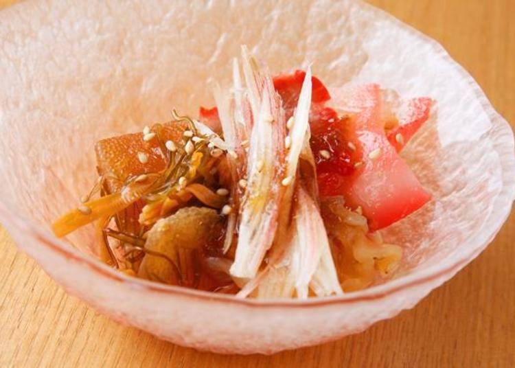 A small bowl dish of whale bacon and jellyfish garnished with herring roe in homemade matsumaezuke (a pickled dish of sliced surume (dried squid) and konbu (dried seaweed)). Goes especially well with Japanese sake!