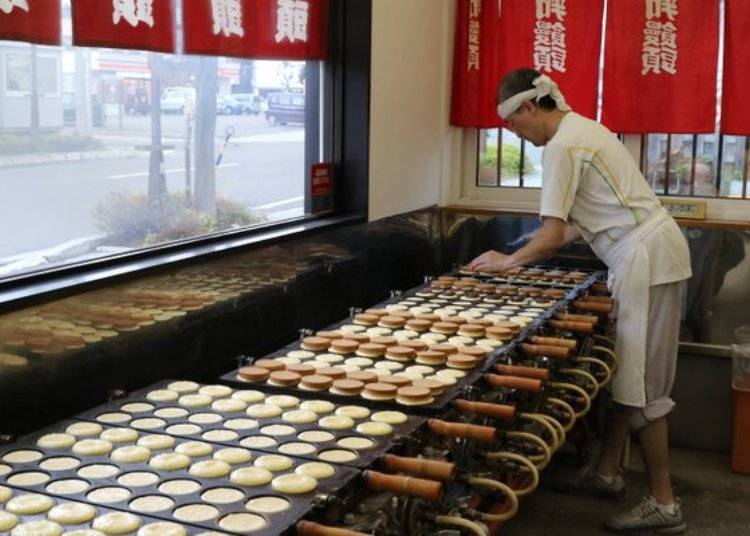 바쁘게 오반야키를 굽고 있는 삼 대째 주인 다카하시 미치아키 씨. 바쁠 때에는 하루에 2,000개를 구운 적도 있다고 한다