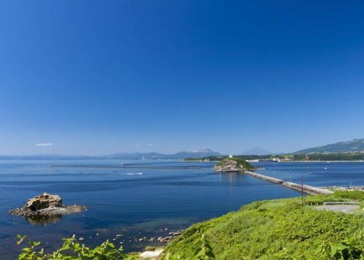 ▲ The view is spectacular on a fine day! Daikoku Island is the bowl-shaped island that is visible beyond the breakwater on the right (Photo courtesy of Muroran Tourism Association)