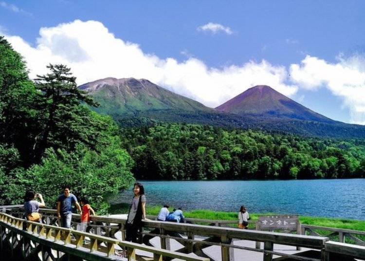 The view of Mt. Meakan-dake (left) and Mt. Akan Fuji (right) from the observation deck which is adjoined by a parking lot. Many people visit here for the spectacular view it affords. (Photo: Ashoro Tourism Association)