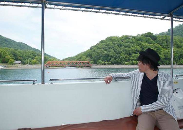 ▲Immediately after setting sailing, the symbol of Lake Shikotsu, the "Yama Line Bridge" can be seen. Among the green mountains and blue lake, this red bridge completes the picture.